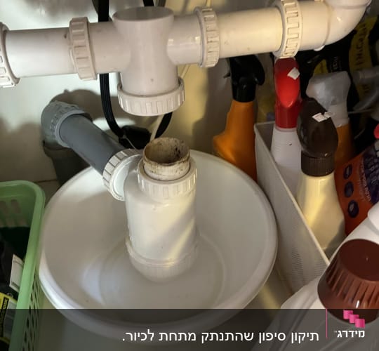 צנרת מתחת לכיור עם חיבורים ומוצרים לניקוי